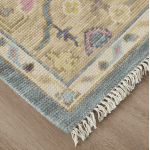 Vintage floral area rug with intricate patterns in silver, green, and pastel shades, perfect for adding elegance to any living space.