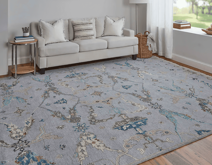 Elegant blue and multi-colored patterned area rug in a cozy living room setting.