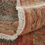 Colored vintage rug with intricate patterns and fringed border, perfect for adding warmth and character to any living space.