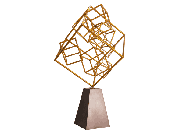 Sculpture featuring interconnected golden metal cubes mounted on a sleek gray pedestal, blending modern art with stylish interior decor.
