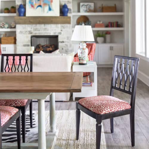 Elegant Dining Area Featuring A Wooden Table, Stylish Chairs With Patterned Cushions, And A Cozy Fireplace With Decorative Shelves.