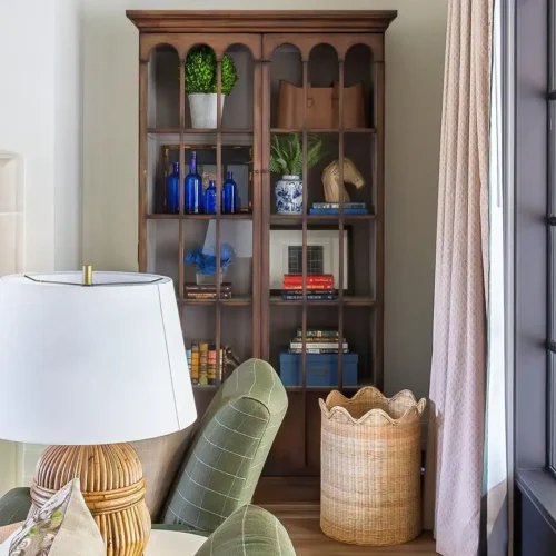 Classic Wooden Bookcase With Decorative Items And Books In A Cozy Living Room Setting.