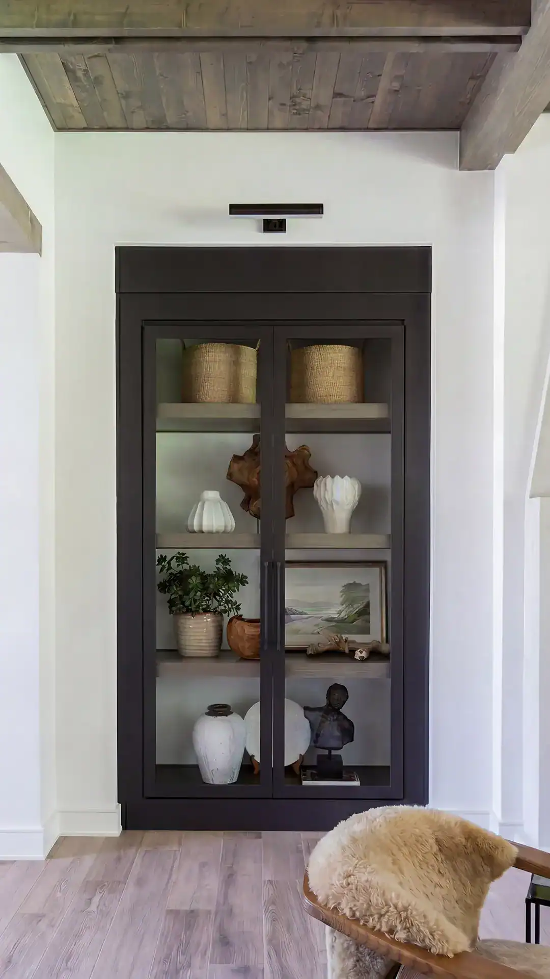 Stylish Black Display Cabinet With Glass Doors Showcasing Decorative Vases, Sculptures, And Artwork, Perfect For Enhancing Interior Spaces In Tyler, Texas.