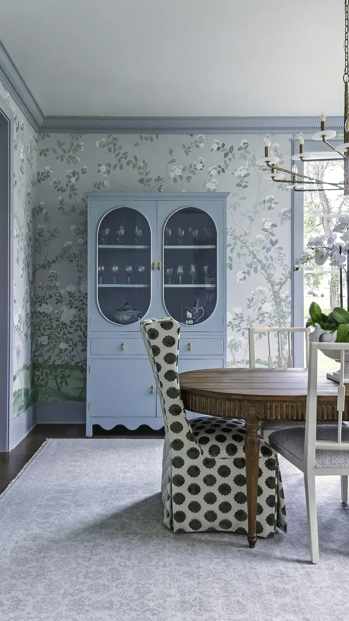 Beautiful Blue China Cabinet With Glass Doors Displaying Dishware In A Stylish Dining Room Setting.