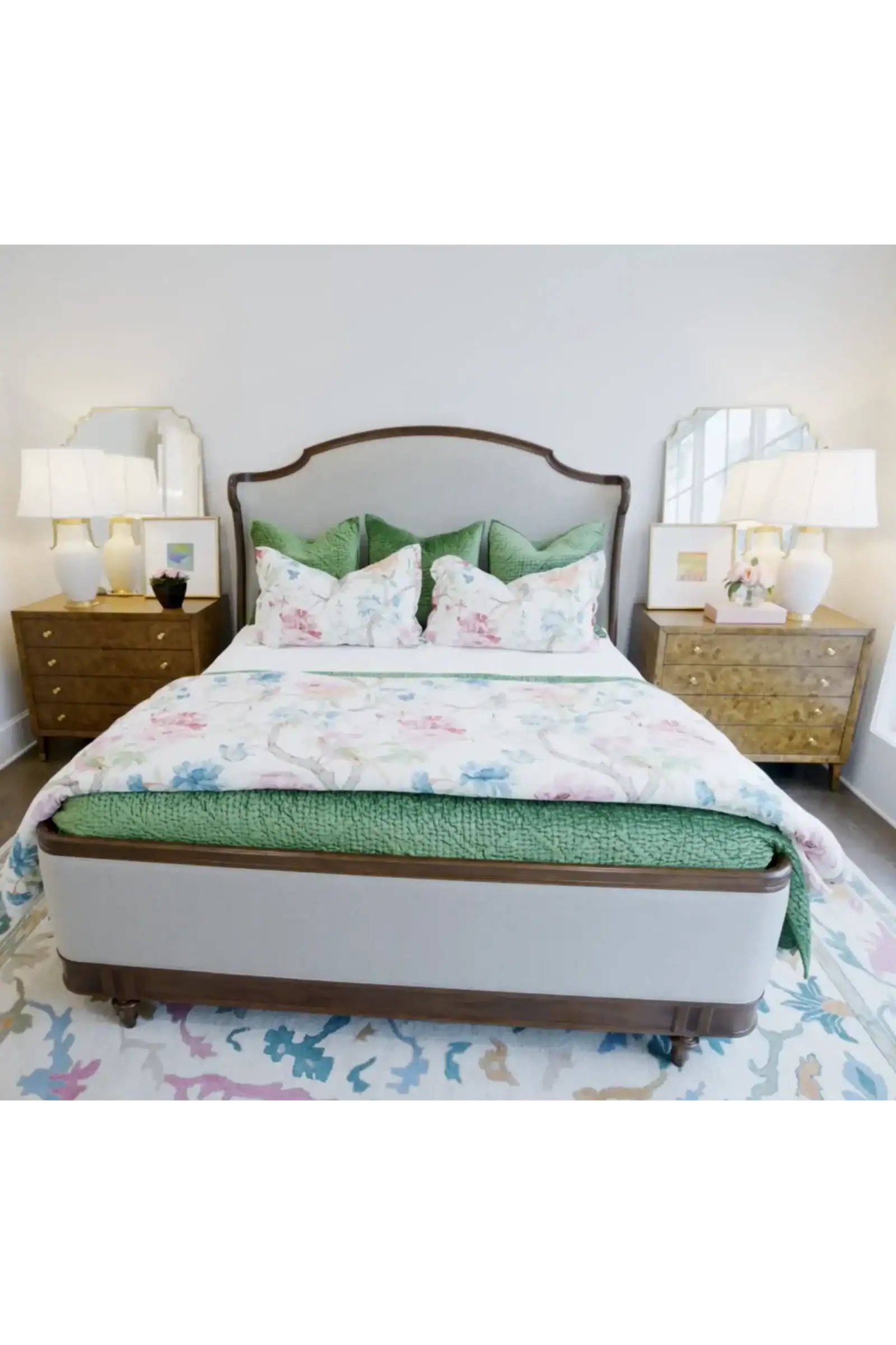 Beautiful Bedroom Featuring A Bed With Green Bedding And Floral Pillows, Flanked By Matching Wooden Nightstands With Lamps, In A Modern Home Setting.