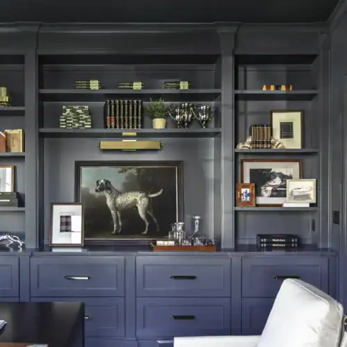 Stylish Blue Built-In Bookcase With Decorative Items, Books, And Artwork In A Modern Interior Setting.