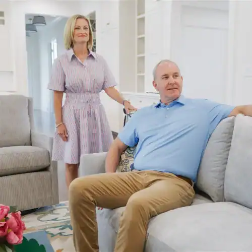 Two Adults In A Modern Living Room With Stylish Furniture, Showcasing Swann'S Furniture &Amp; Design In Tyler, Texas.
